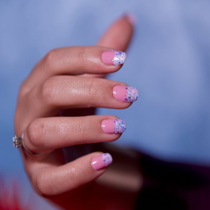 Soft pink nails with sparkly glitter French tips.